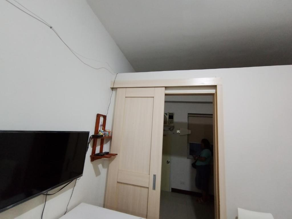 a room with a flat screen tv and a bathroom at Fully Furnished 1 Bedroom Condo Unit in Manila