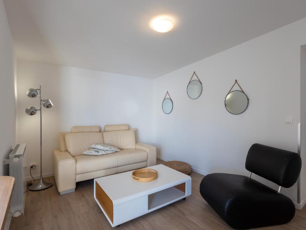 a living room with a couch and a chair at Ty Bihan by Madame Est Servie in Pleumeur-Bodou