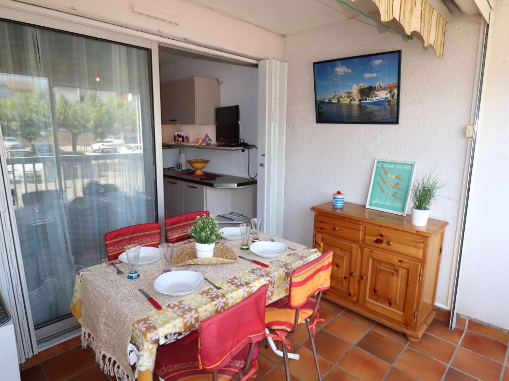 une salle à manger avec une table et des chaises et une fenêtre dans l'établissement Appartement T2 avec terrasse et parking à 350m de la plage, proche commerces. - FR-1-307-217, au Grau-du-Roi