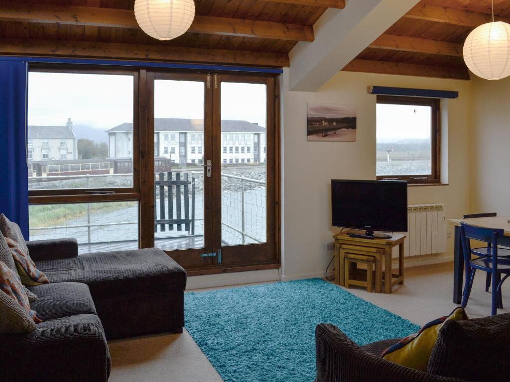 a living room with a couch and a flat screen tv at Ffestiniog View in Porthmadog