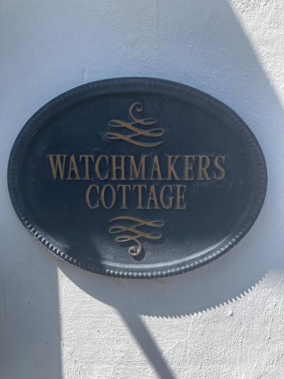 a sign on a wall with the waterimakes cottage at Watchmaker Cottage in Bellingham