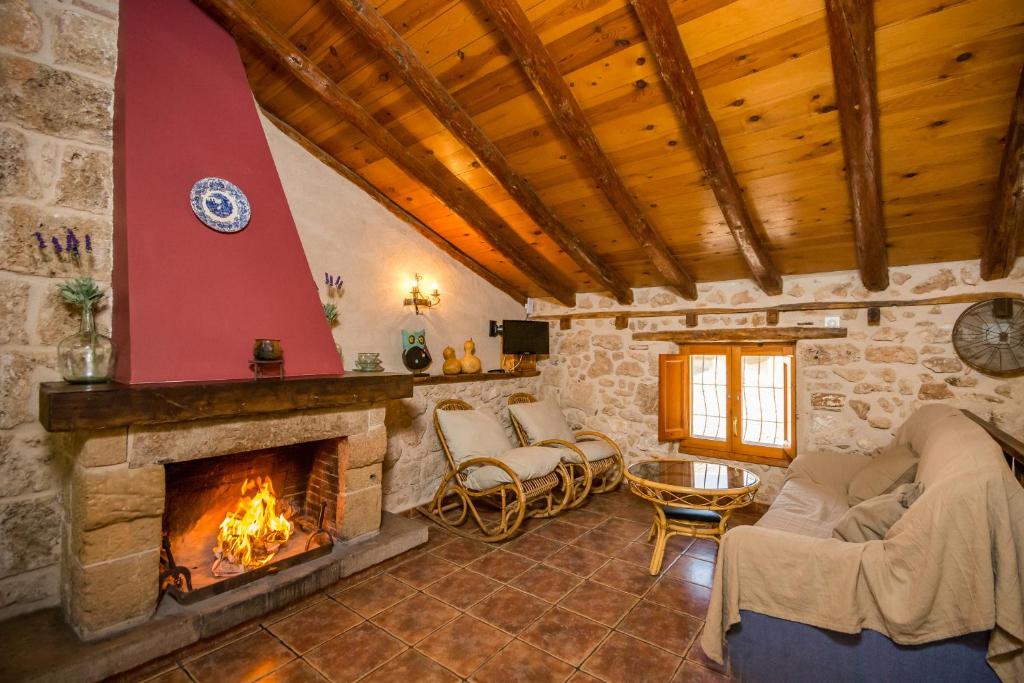 una sala de estar con chimenea de piedra en una casa en Casa Ana, en Beceite