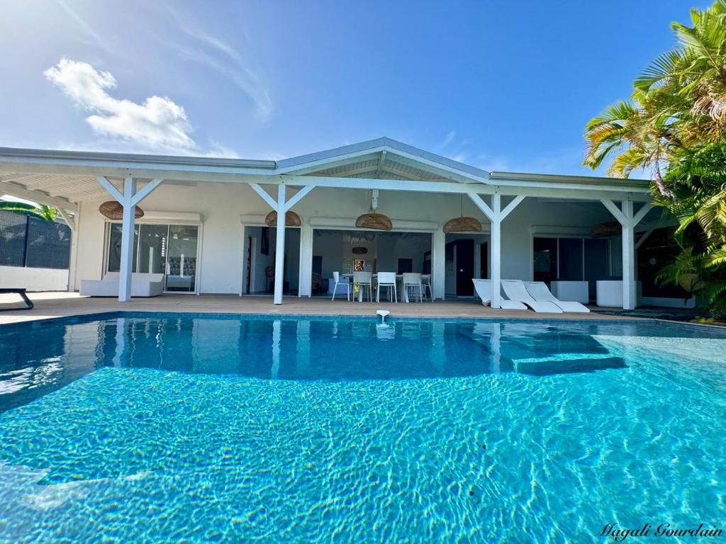 a swimming pool in front of a house at Villa Cokoon in Saint-François