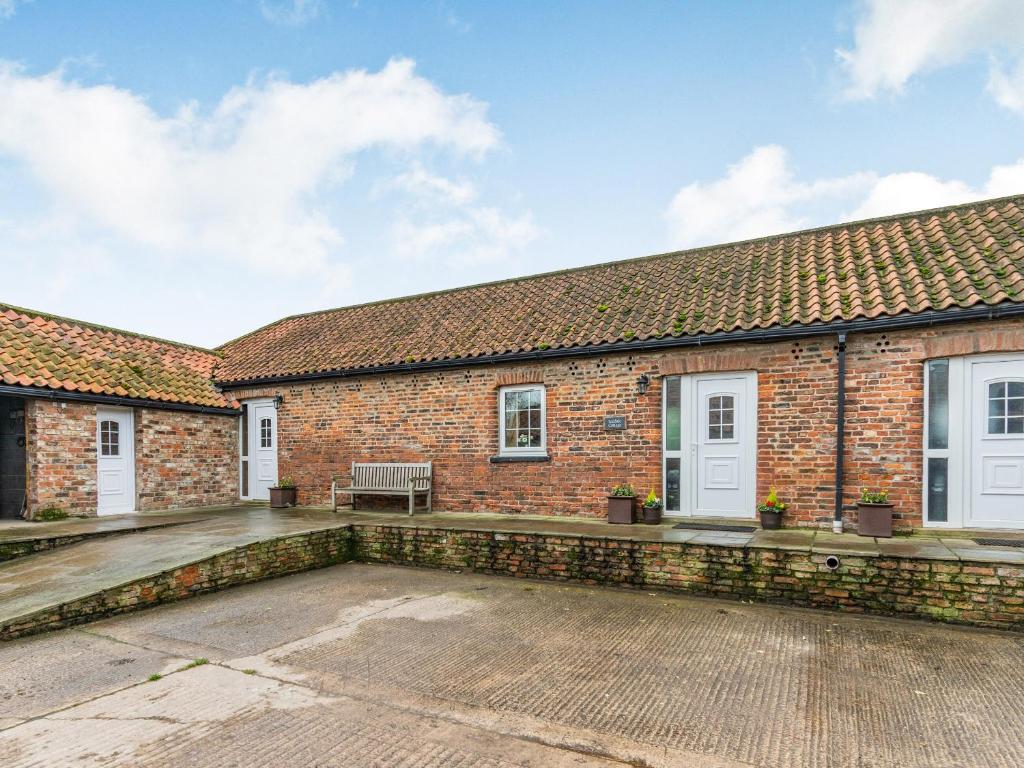 an exterior view of a brick building with a patio at Leedale Cottage in Saltmarshe