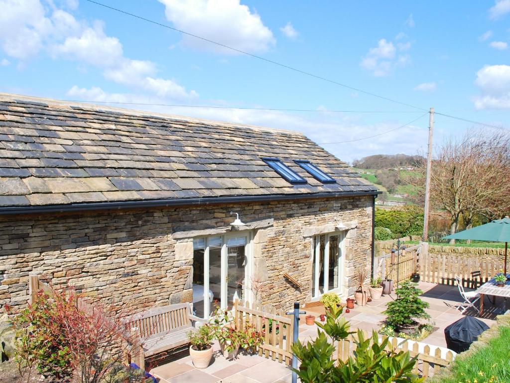 une maison en pierre avec des puits de lumière sur le toit dans l'établissement Appleshine Cottage, à Almondbury