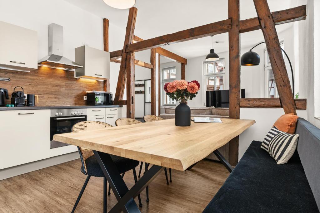 eine Küche mit einem Holztisch mit einer Blumenvase in der Unterkunft LIGHTHOUSE - Perfekt für Gruppen - 2 Whg - Zentral - PS5 & Switch in Rotenburg an der Fulda