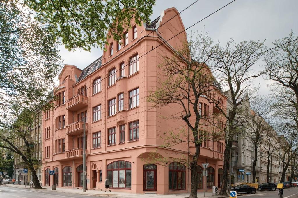 a large pink building on a city street at Between the roofs of Jeżyce in Poznań