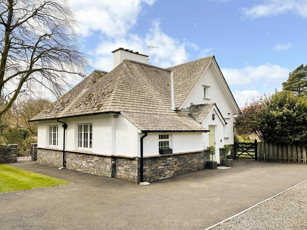 a white house with a roof on a driveway at Granton Lodge in Far Sawrey