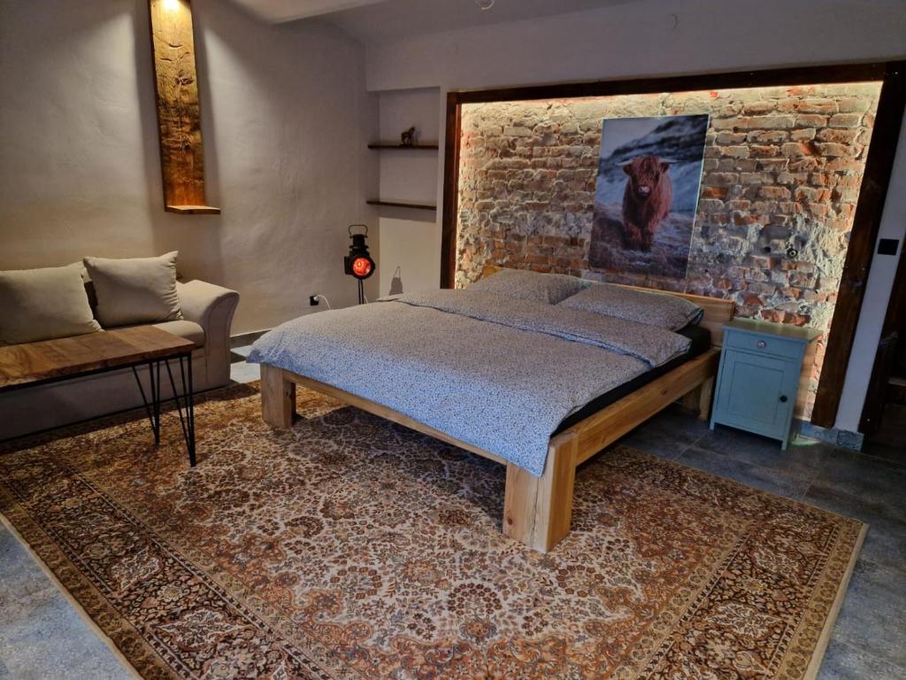 una camera da letto con un letto e un muro di mattoni di Siedlisko na Roztoczu - Dom pod Lipami 