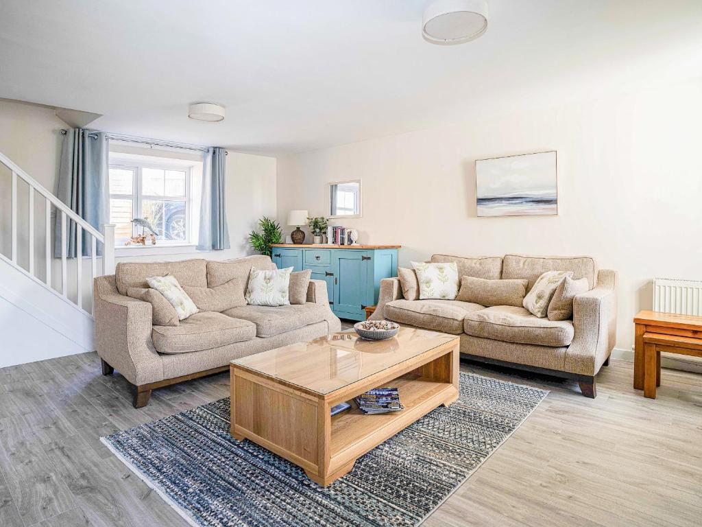 Una sala de estar con dos sofás y una mesa de café. en Rosslyn Cottage, en Portmahomack