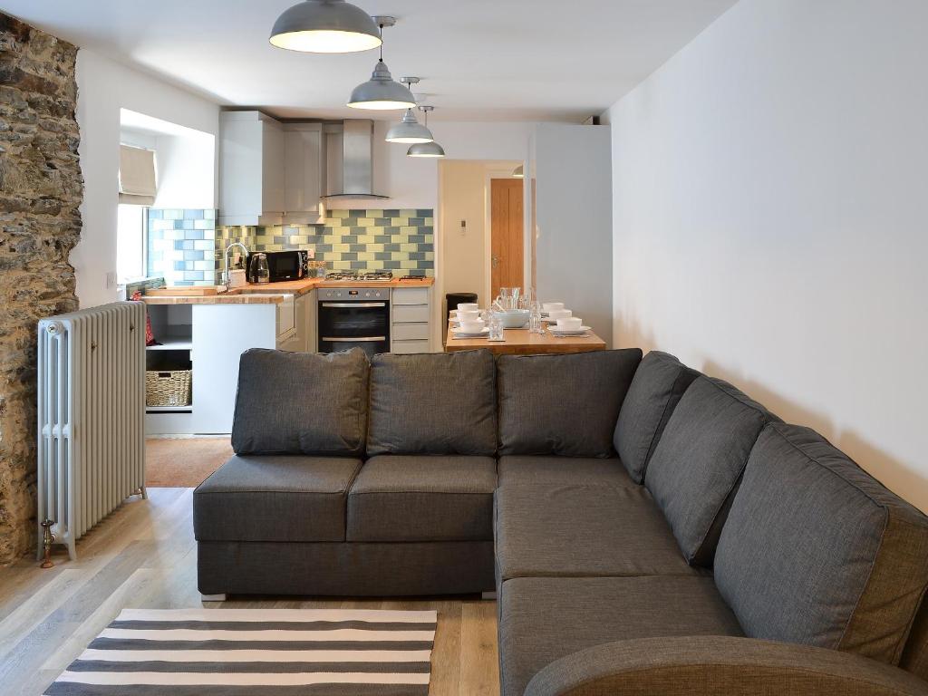 Una sala de estar con un sofá y una cocina. en Rosetta Apartments - Ocean Mist, en Newquay