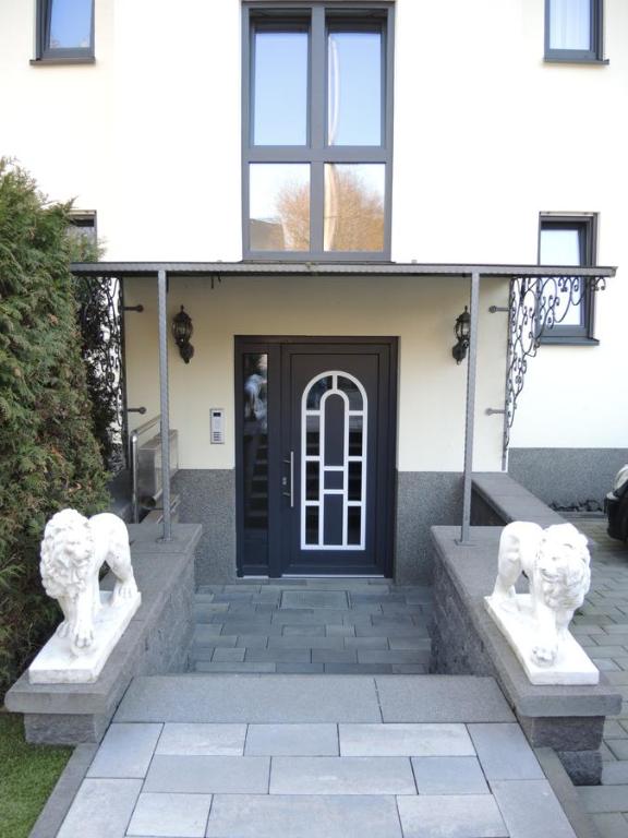 uma casa com duas estátuas em frente a uma porta em Merkel Villa Apartamente em Wiesbaden