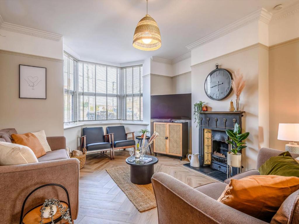 a living room with couches and a fire place at Wisteria Cottage in Heacham