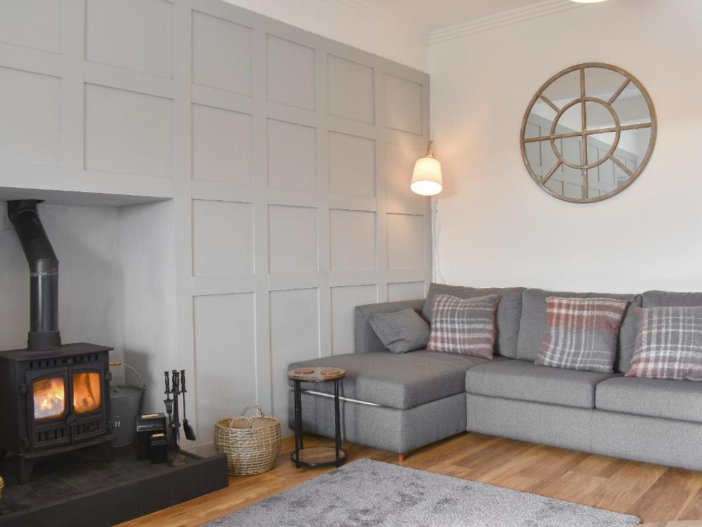 a living room with a couch and a fireplace at Loanmhor in Kilmory