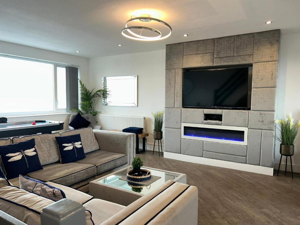 a living room with a couch and a tv at Seaview House in Thornton