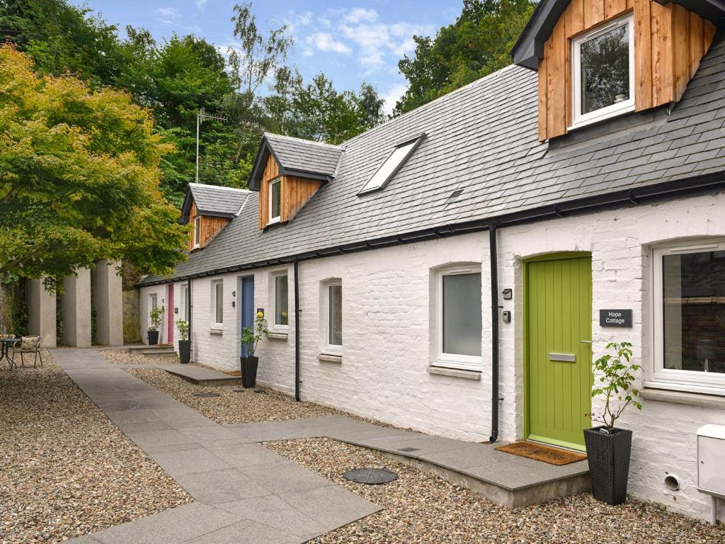 een rij huizen met een groene deur bij Hope Cottage - Uk40055 in Aberfeldy