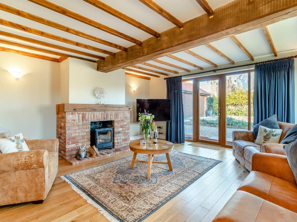 a living room with a couch and a fireplace at Landers Mews in Trunch