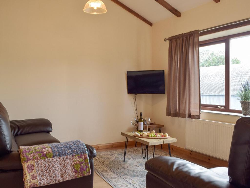 ein Wohnzimmer mit Sofa und Tisch in der Unterkunft Caws Cottage - Lancych in Cenarth
