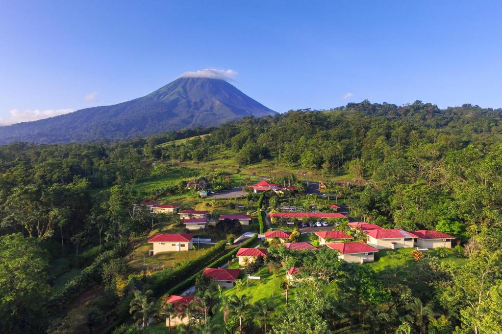 a village on a hill with a mountain in the background at Arenal Volcano Inn in Fortuna