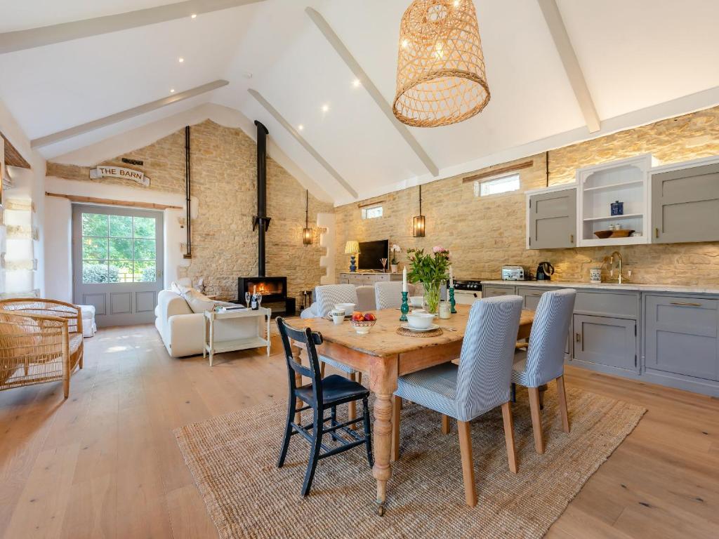 una cucina e un soggiorno con tavolo e sedie in legno di The Barn a Shipton under Wychwood