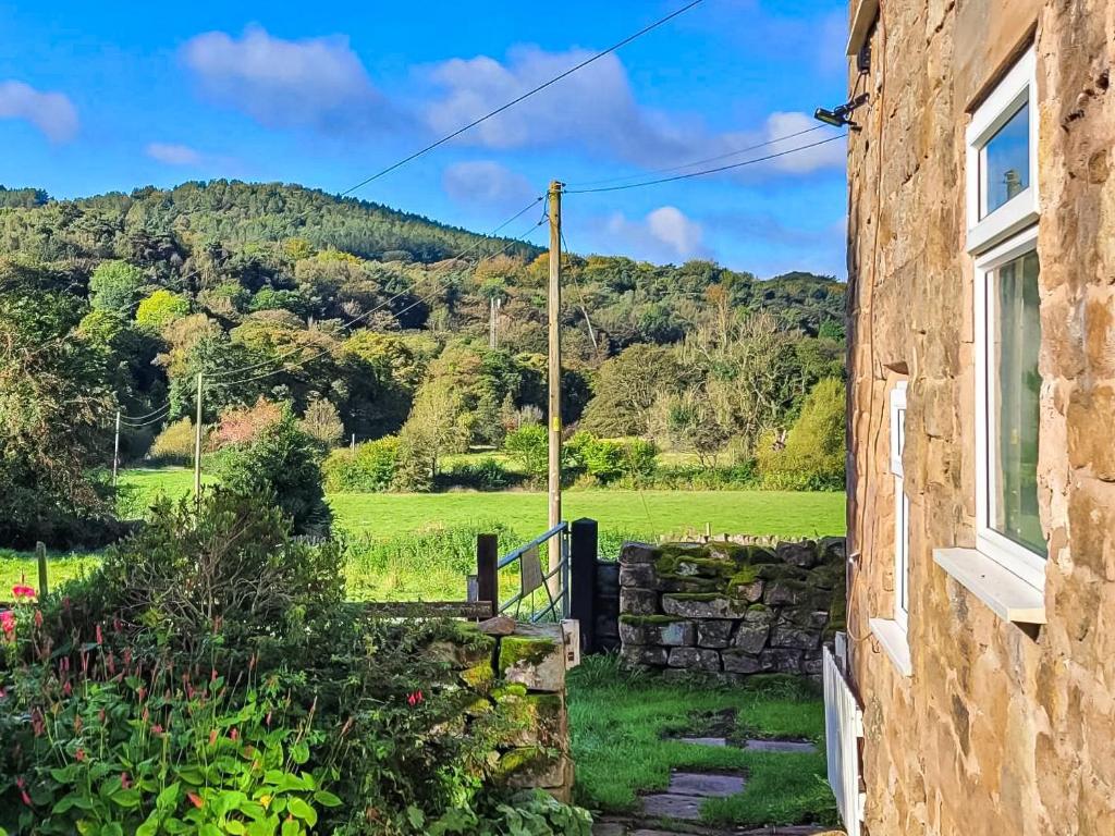 a house with a window and a view of a field at Meadow View Cottage in Highpeak Junction