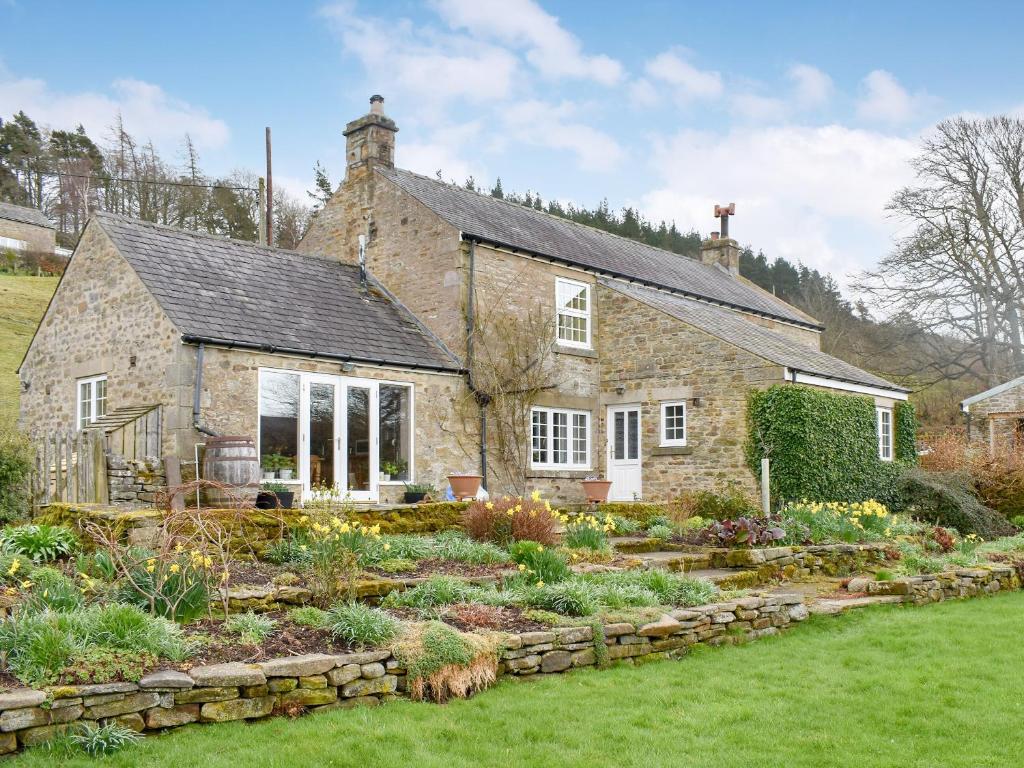 a stone house with a garden in front of it at Black Bank House in Studdon