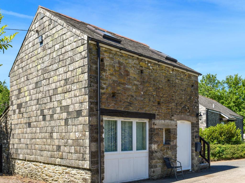 a brick cottage with a white garage door at The Stable - Uk49829 in Callington