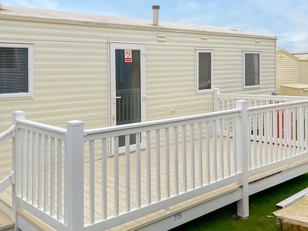 a mobile home with a white fence at Farne Lodge in Berwick-Upon-Tweed