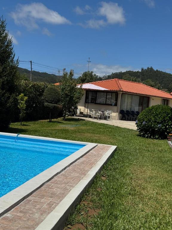 a house with a swimming pool in the yard at Oliveira's Little House in Caminha