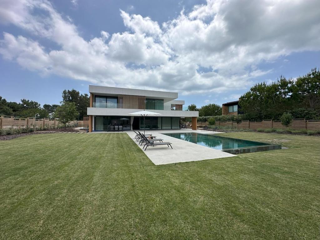 a house with a large yard with a swimming pool at Casa Atlântica 26 in Troia