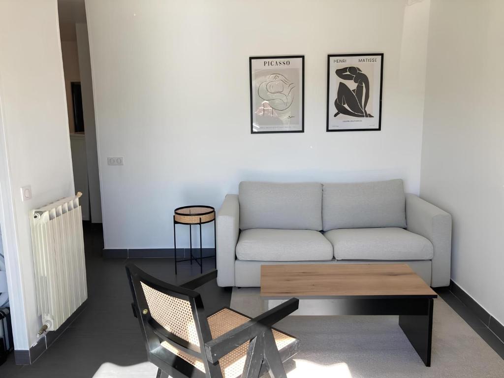 un salon avec un canapé et une chaise dans l'établissement Superbe Appartement 2p avec place de parking, à Antibes
