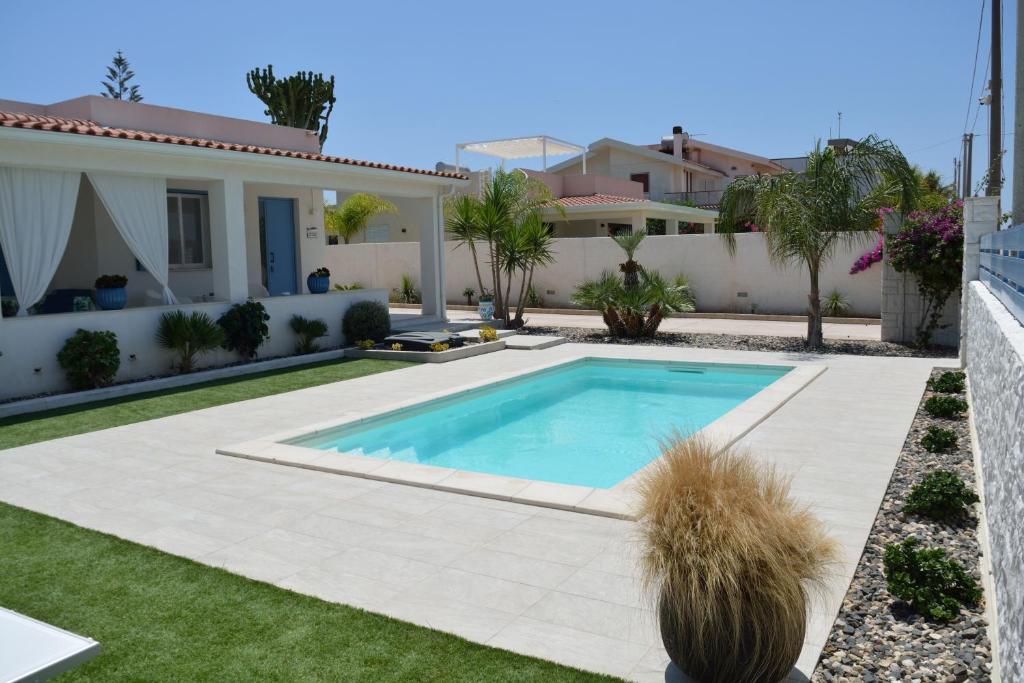 a swimming pool in the yard of a house at Villa Colapesce in Marzamemi