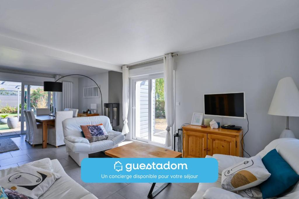 a living room with a couch and a table at Le Boucard - Terrasse - Proche plage in Saint-Nazaire