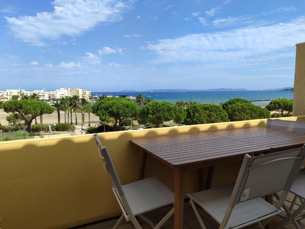 a table and chairs on a balcony with a view of the ocean at L'endroit in Bormes-les-Mimosas