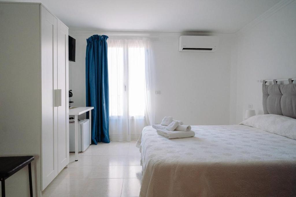 a white bedroom with a teddy bear sitting on a bed at La Quiete in Scilla