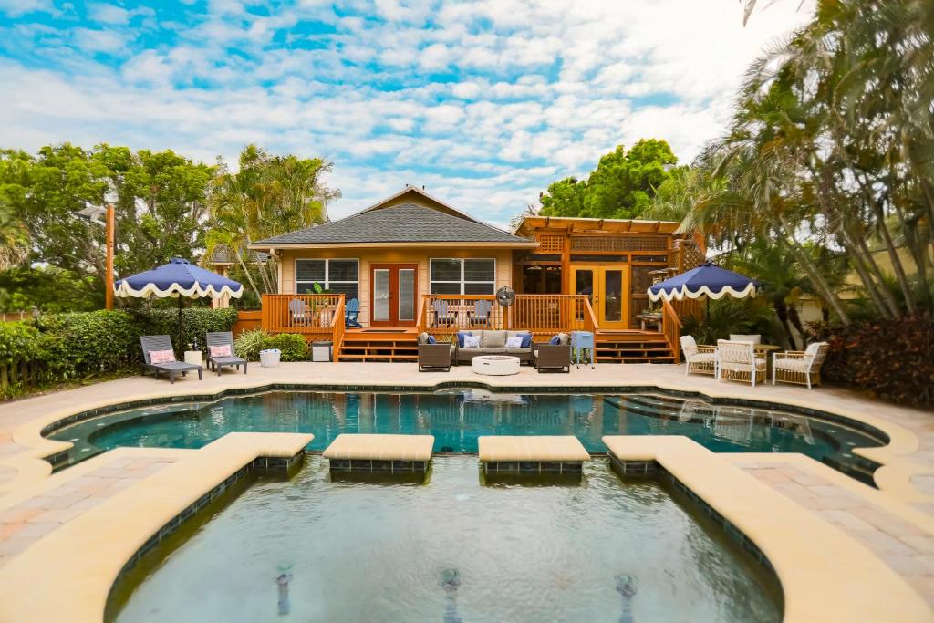 a house with a swimming pool in front of a house at Tuscan Breeze - Pool, Beach, Games, Dog Park, Movies in Palm Harbor