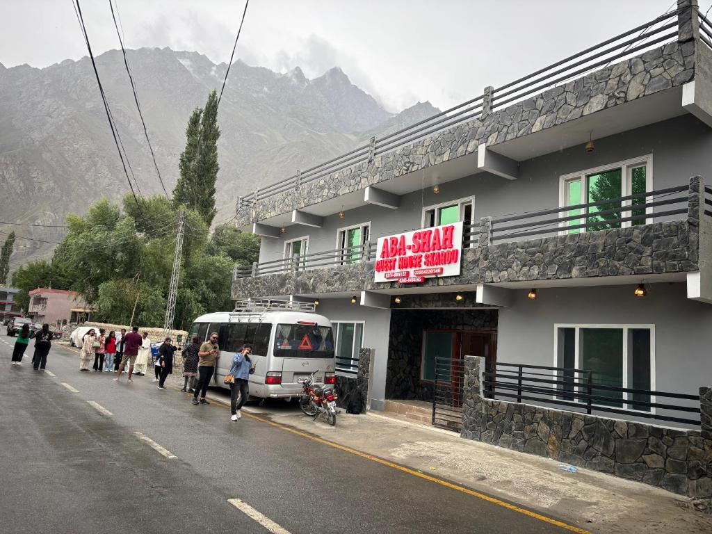锡卡都Aba-SHAH GUEST HOUSE SKARDU的一群人沿着大楼旁边的街道走着