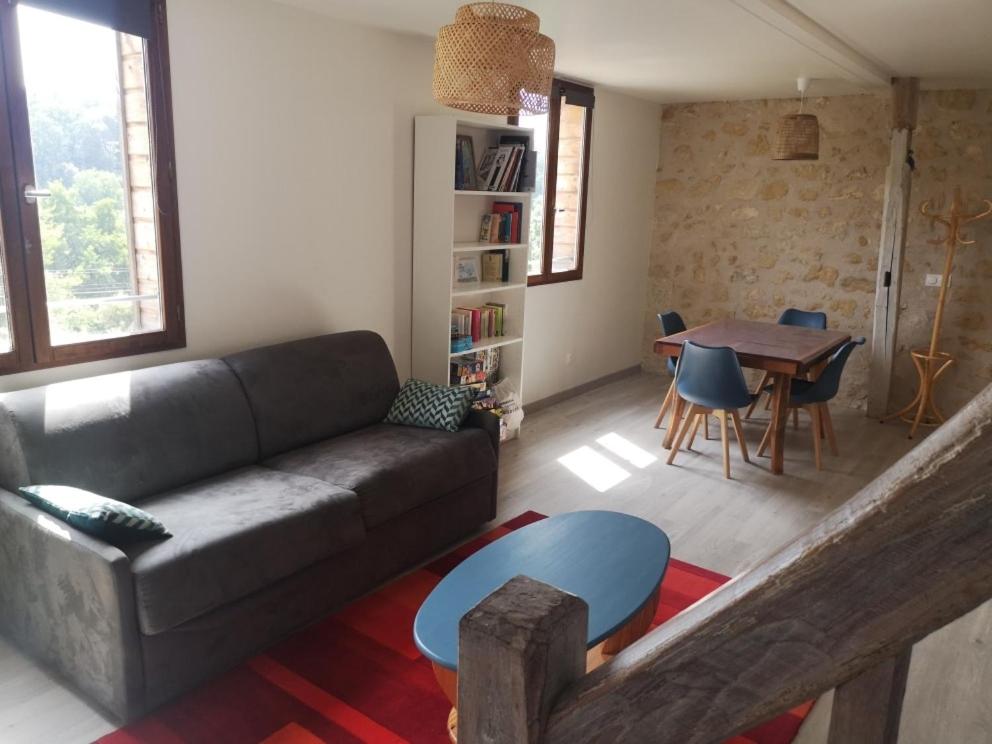 a living room with a couch and a table at Cottage en nature Le Pigeonnier de la Manse in Saint-Épain