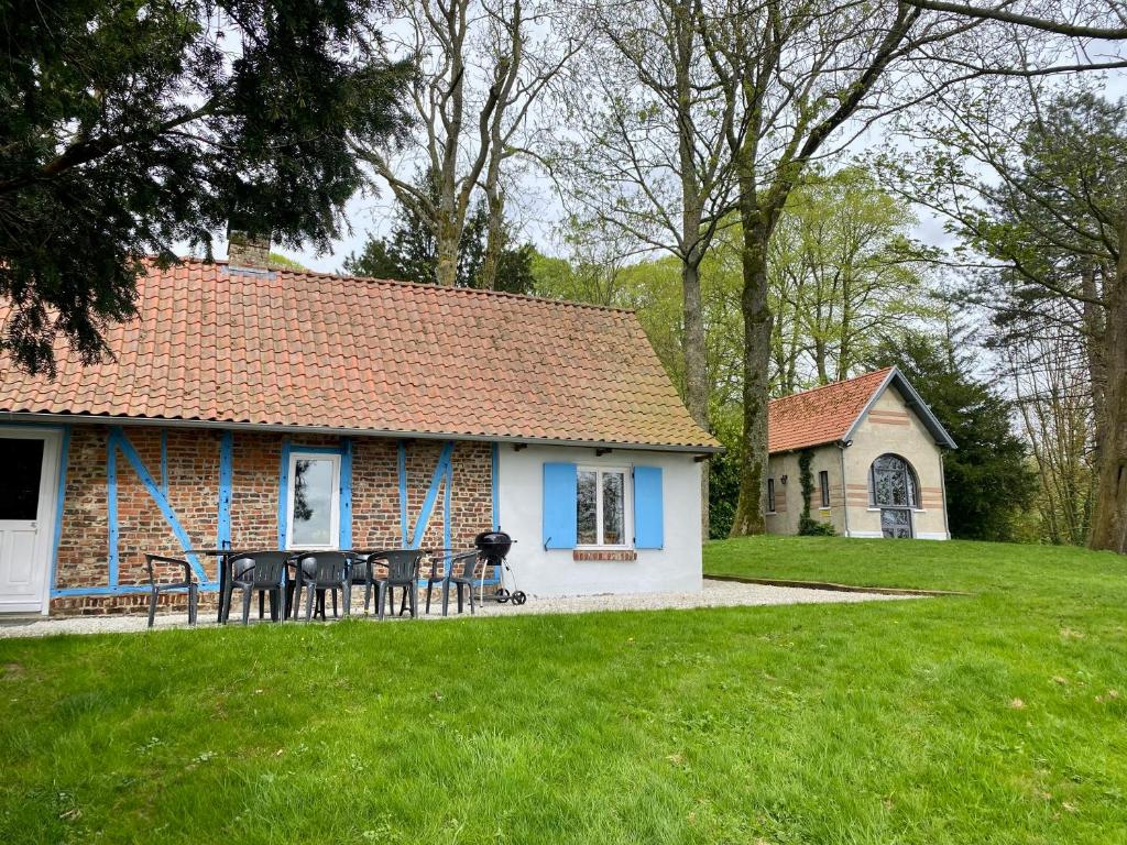 a house with tables and chairs in a yard at Les gîtes du Tilleul de Cassel in Cassel