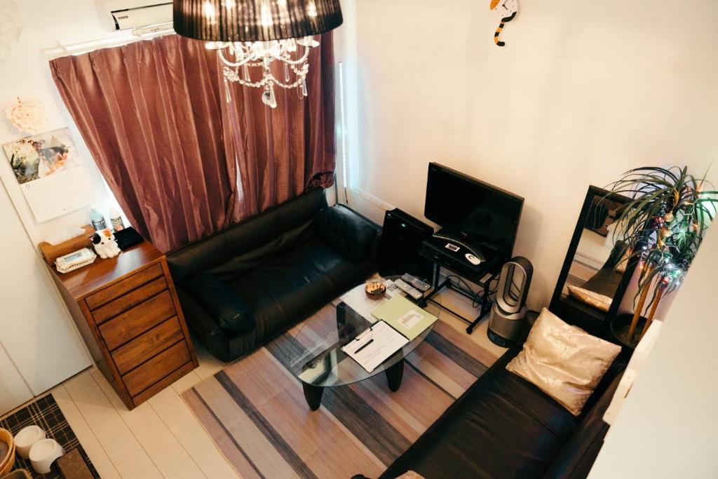 a living room with a black leather couch and a table at Designer's apartment polaris 102 - Vacation STAY 13315 in Nagoya