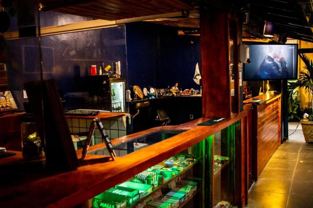 un bar con bancone e televisore in camera di Surf & Arte Hostel a Cabo Frio
