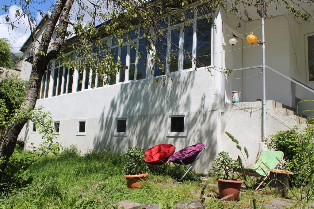 zwei Stühle im Gras vor einem Gebäude in der Unterkunft Villa Gabliani in Mestia