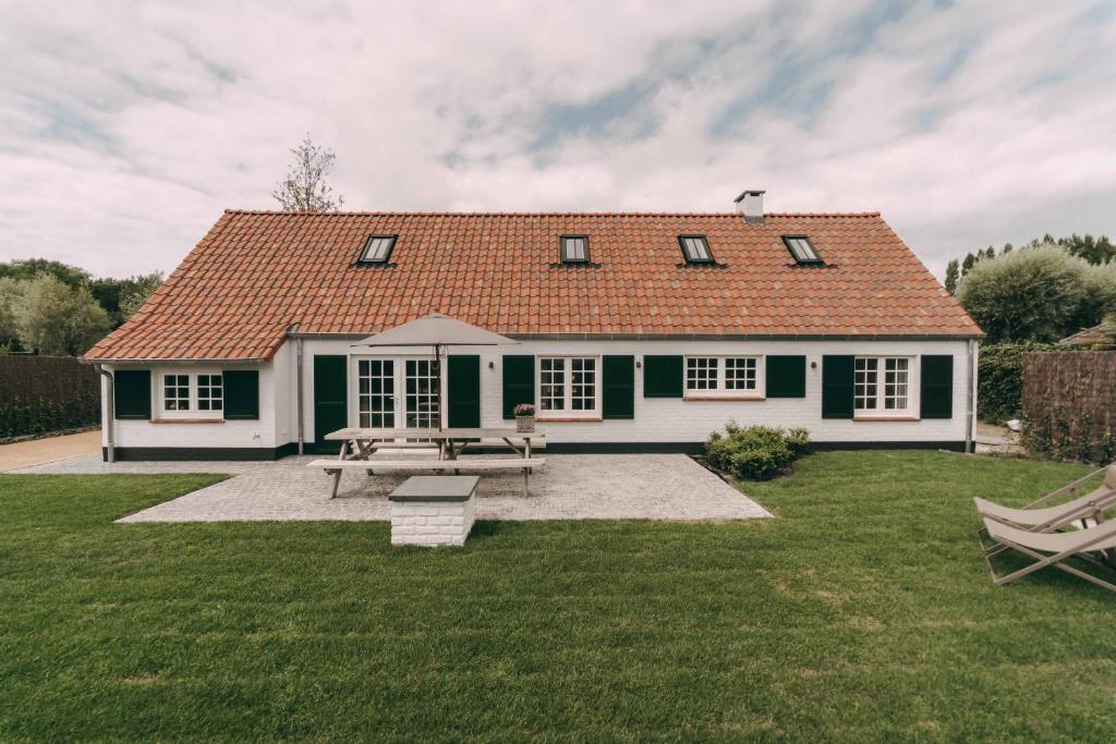 a house with a picnic table in the yard at Crevetje in Koksijde