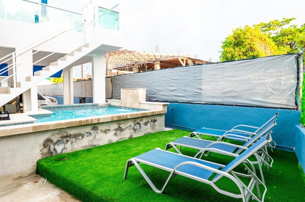 twee stoelen op het gras naast een zwembad bij La Casita Blanca - Sun in Fajardo