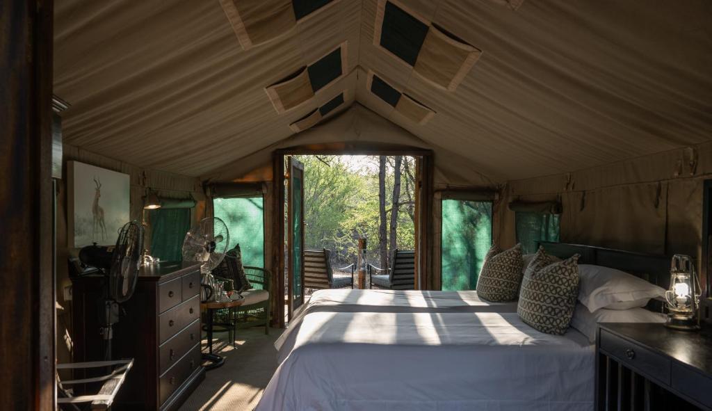 een slaapkamer met een groot bed in een huis bij Mashatu Tent Camp in Lentswelemoriti