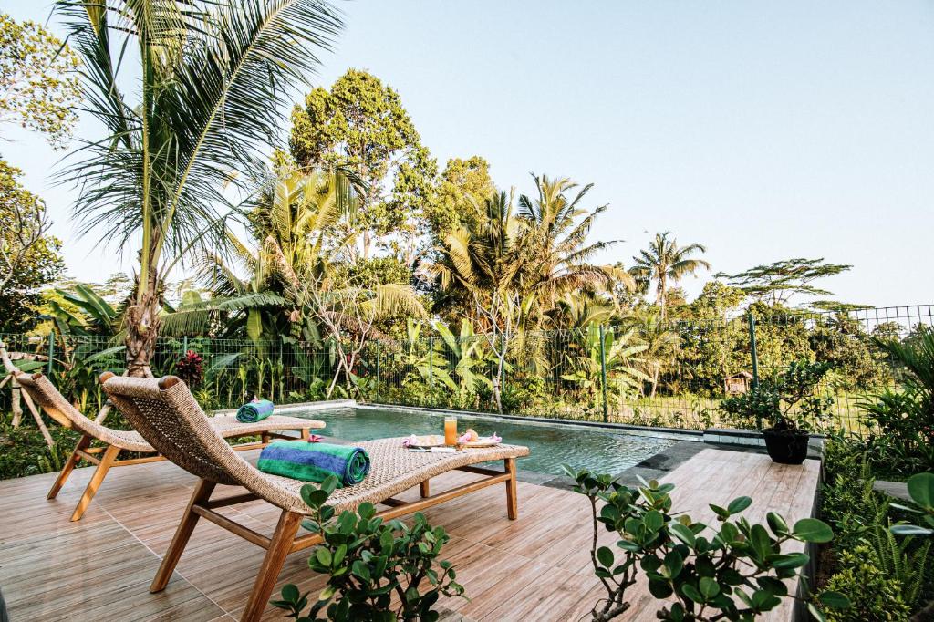 a patio with a table and chairs next to a pool at Villa Kerta Ubud in Gianyar