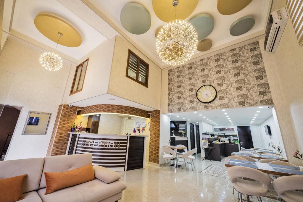 Una sala de estar con un sofá y un reloj en la pared. en Turkish Sultan Hotel, en Tiflis