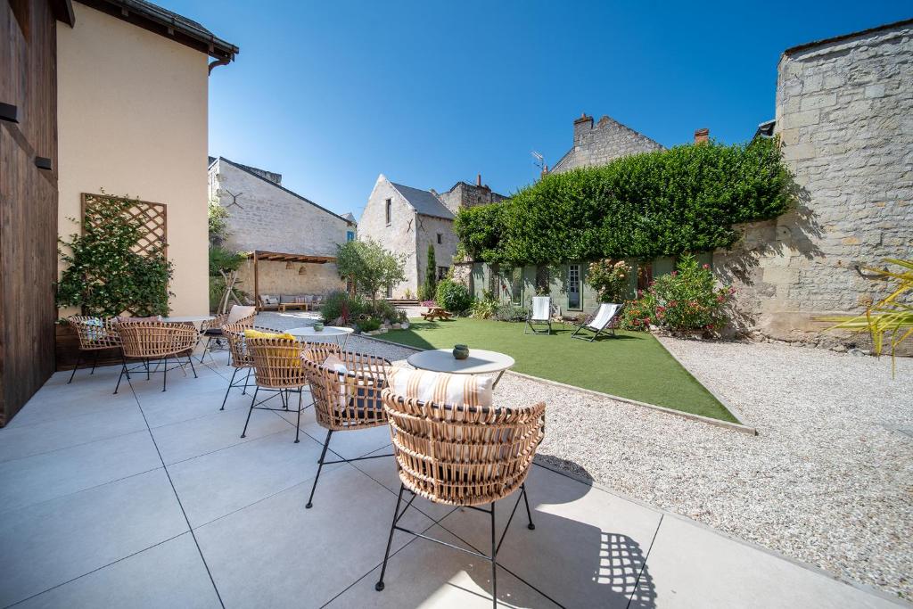 eine Terrasse mit Stühlen und Tischen in einem Innenhof in der Unterkunft Hôtel Rive Sud in Chinon