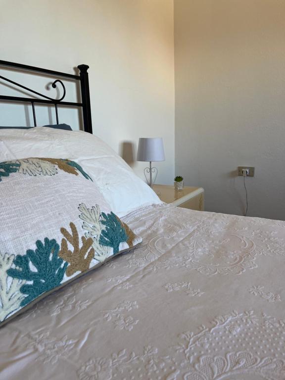 Un dormitorio con una cama con una almohada encima. en DA BARBARINA Casa Vacanze sud Sardegna, en Capoterra