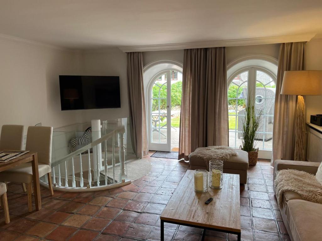 a living room with a couch and a table at Hygge Suite Sylt Kampen in Niederdorla